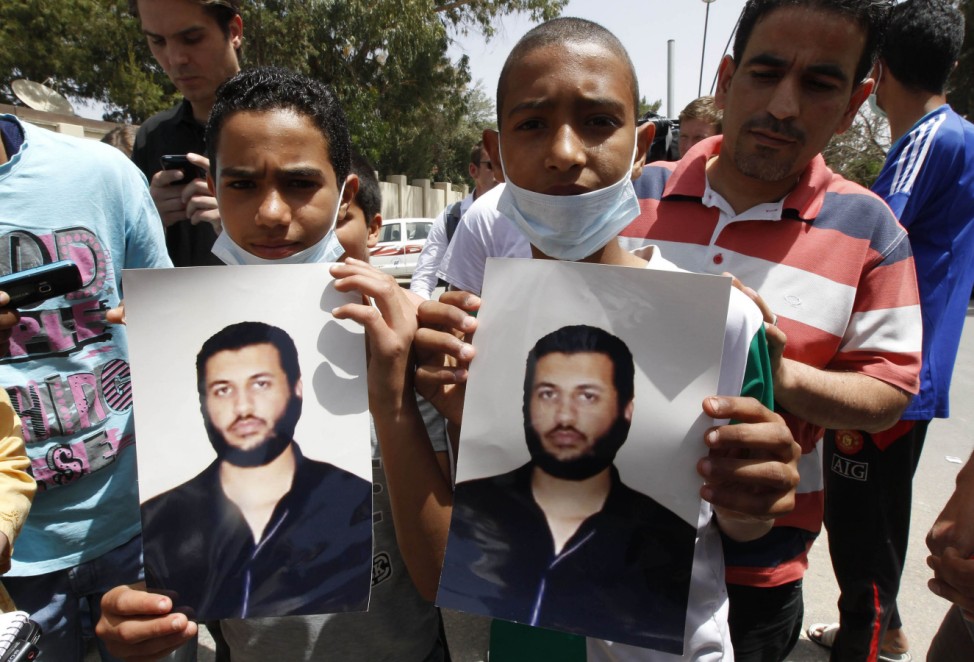 Young men hold pictures of Saif Al-Arab Gaddafi, son of Libyan leader Muammar Gaddafi, in Tripoli