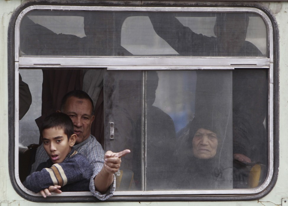 Egyptians look from a bus during clashes between protesters and riot police at Tahrir Square in Cairo