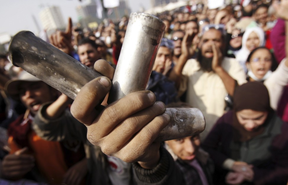 A protester displays empty tear gas canisters during clashes with riot police at Tahrir Square in Cairo