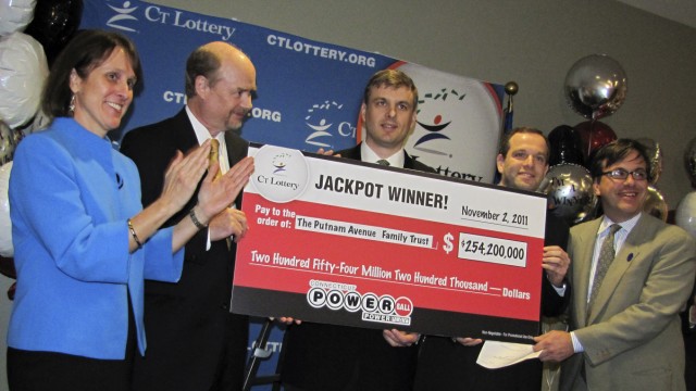 Lotto in den USA: Gruppenbild mit Geld: Die Finanzmanager Tim Davidson (2. v. l.), Greg Skidmore (Mitte) und Brandon Lacoff (2. v. r.) mit ihrem Lotto-Scheck über 254,2 Millionen Dollar - umgerechnet 190 Millionen Euro.