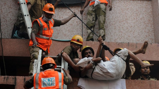 Brandkatastrophe in Kolkata: Gefährlicher Einsatz: Um Menschen aus den oberen Stockwerken des Krankenhauses zu retten, seilte die indische Feuerwehr die Patienten ab.