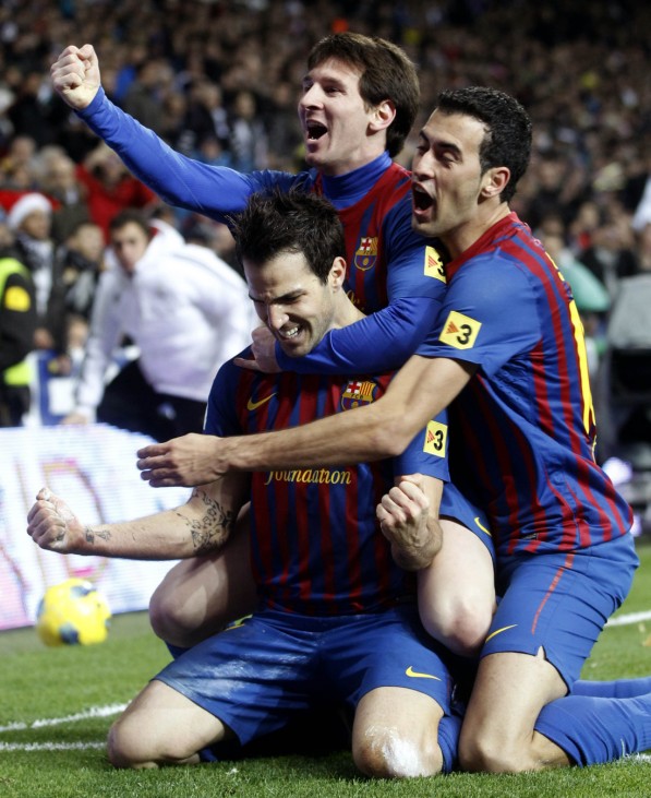 Barcelona's  Cesc Fabregas celebrates his goal with his team mate Lionel Messi and Sergio Busquets against Real Madrid  during their match Spanish first division soccer match, the 'Clasico',  at the Santiago Bernabeu stadium in Madrid