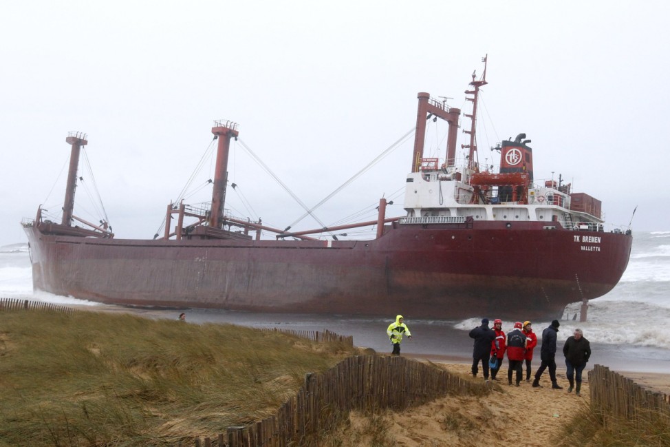 French gendarmes and rescue workers survey grounded cargo ship in western France