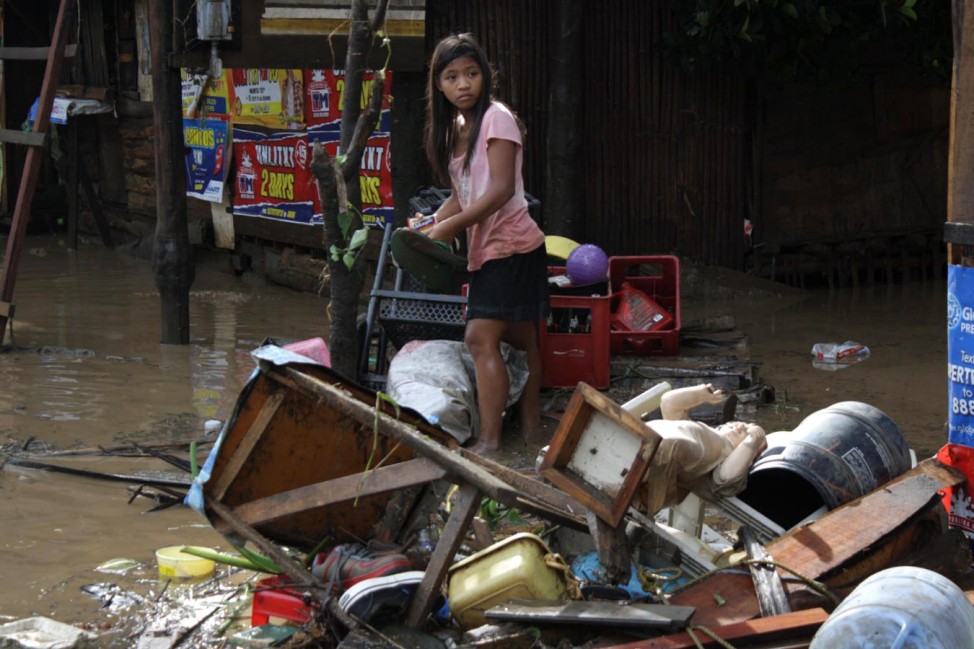 A girl searches for salvageable items after flash floods brought by Typhoon Washi in Macasandig town, Cagayan De Oro city