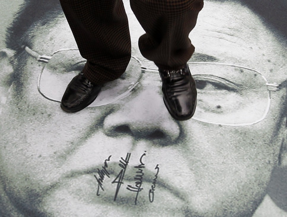 A protester stands on a portrait of North Korean leader Kim Jong-il during an anti-North Korea rally in central Seoul