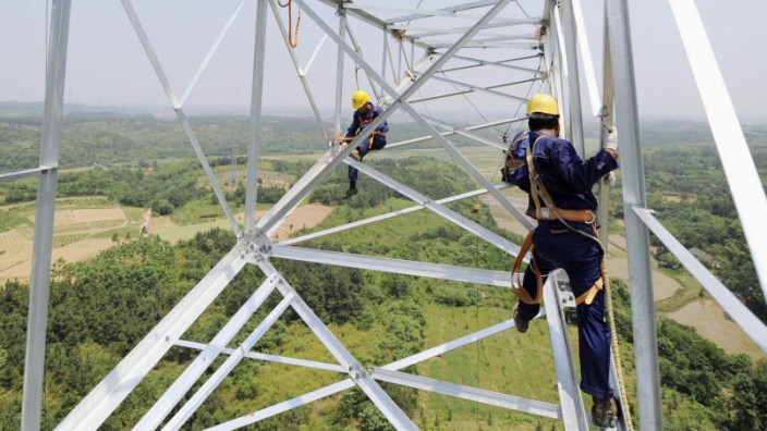 Workers install a high voltage electricity pylon in Xuancheng