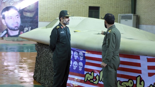 Mysteriöser Angriff auf Militärbasis: In Iran war der getötete Hassan Teherani Moghaddam ein Held. Hier ist er im Hintergrund auf einem Plakat zu sehen - vorne die US-amerikanische Drohne, die dem Regime in Teheran in die Hände gefallen war.