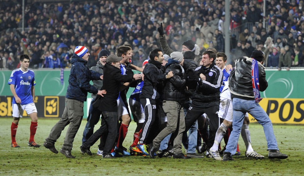 Staff and team members and supporters of Holstein Kiel celebrates after winning against Mainz 05 during their German soccer cup (DFB-Pokal) match in Kiel