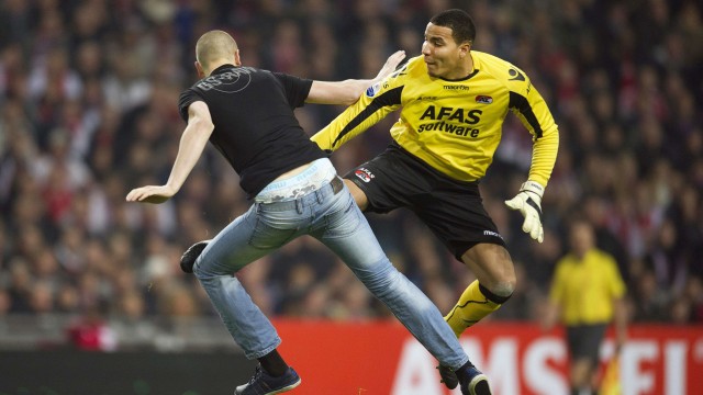 Spielabbruch in Holland: Wilde Szenen: Alkmaars Torwart Esteban Alvarado Brown tritt einen Ajax-Fan. Der hatte ihn zuvor jedoch attackiert.