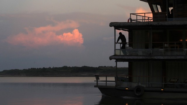 A man travels on a ship across the Maranon river, one of the two main headwaters of the Amazon river