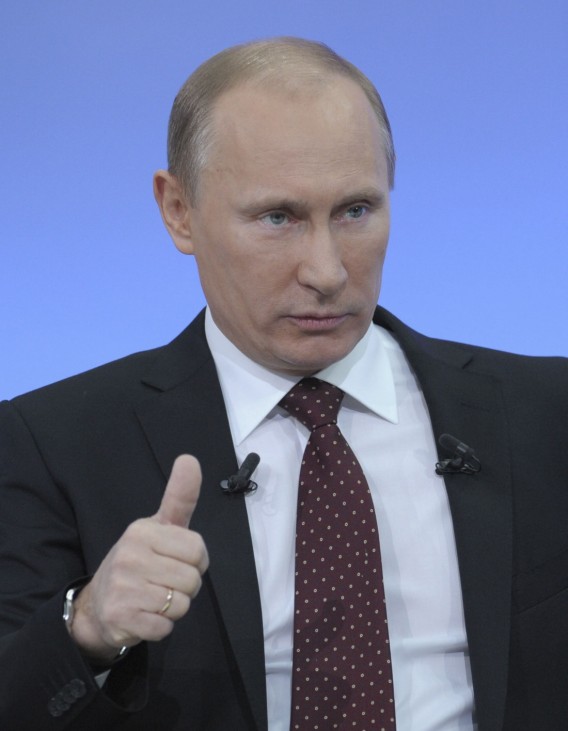 Russian PM Putin gestures during a televised question and answer session in Moscow