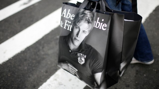 A man holds shopping bags while waiting to cross a street in New York