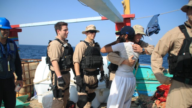 US-Coup am Persischen Golf: Überglücklich über die günstige Fügung: die amerikanischen Retter, wie auch die iranischen Fischer, die von Piraten gekidnappt worden waren. Fürs Foto gab es dann außerdem noch eine Baseball-Kappe geschenkt.
