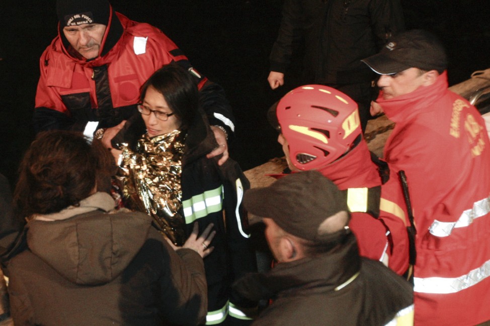 South Korean woman is helped after been rescued with her husband from Costa Concordia cruise as it ran aground off the west coast of Italy at Giglio island