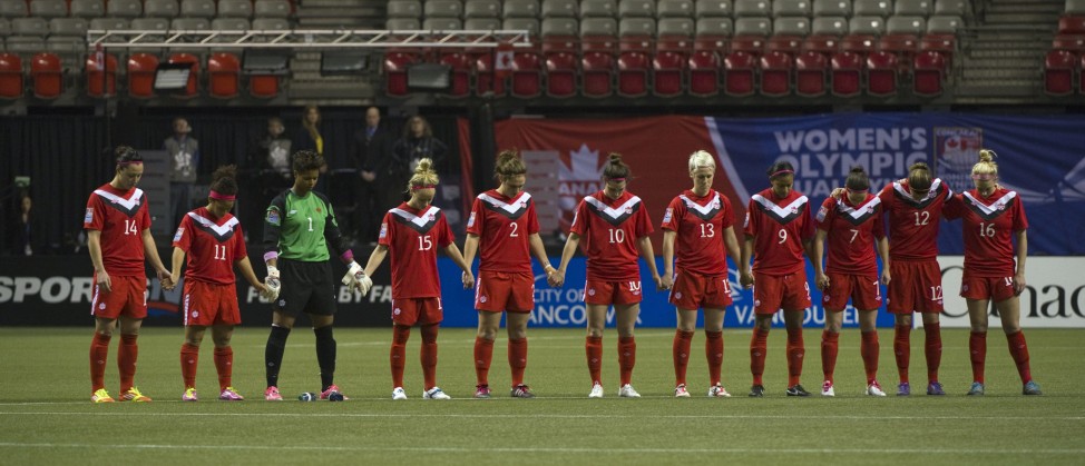 Canadian teams stand for a moments silence for Sarah Burke prior to their CONCACAF Women's Olympic Qualifying soccer game in Vancouver