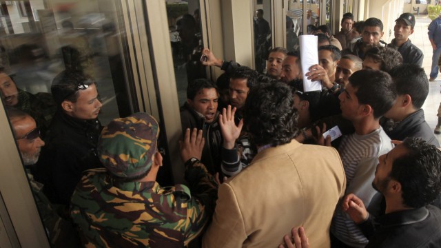 People wounded from the war attempt to enter the NTC headquarters in Benghazi