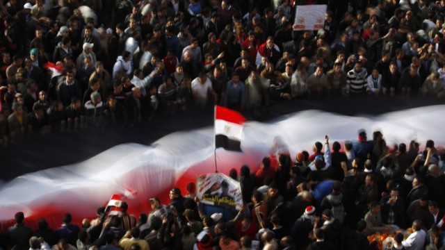 Demonstranten halten eine riesige ägyptische Fahne auf dem Tahrir-Platz