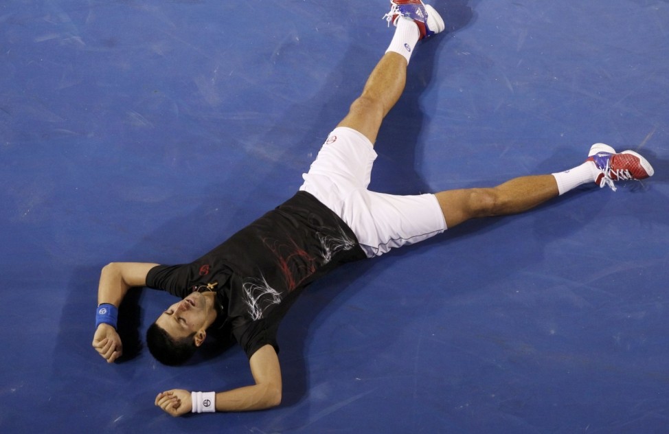 Djokovic of Serbia falls to the floor after a long rally in the fifth set against Nadal of Spain at the Australian Open in Melbourne