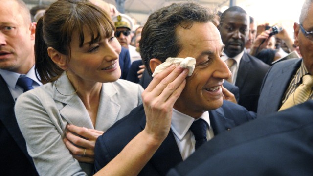 File photo of France's First Lady Bruni-Sarkozy wiping the brow of her husband, France's President Sarkozy, as they visit a market in Fort-de-France