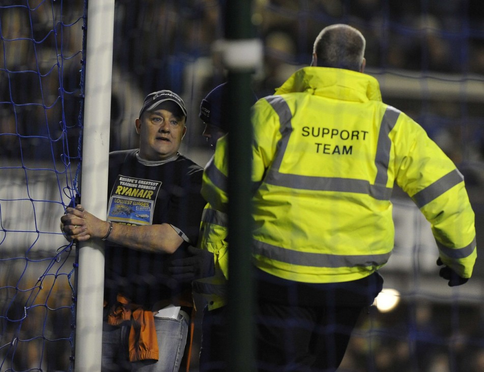 A man handcuffs himself to the goal post during the English Premier League soccer match between Everton and Manchester City in Liverpool
