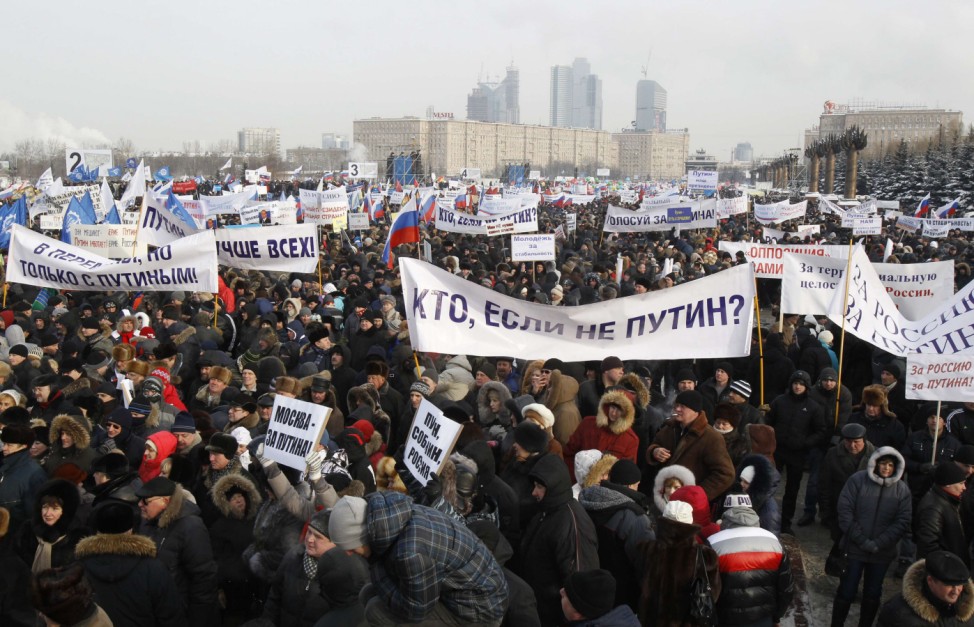 Activists gather, holding banners and placards, in a show of support for Russia's PM Putin in central Moscow