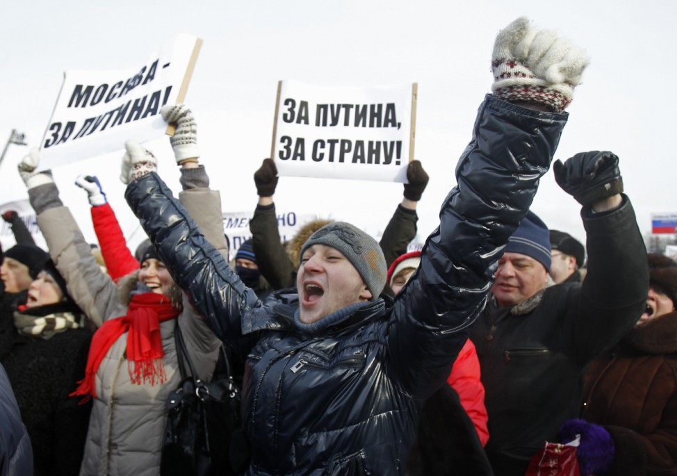 Activists shout slogans during a show of support for Vladimir Putin in central Moscow