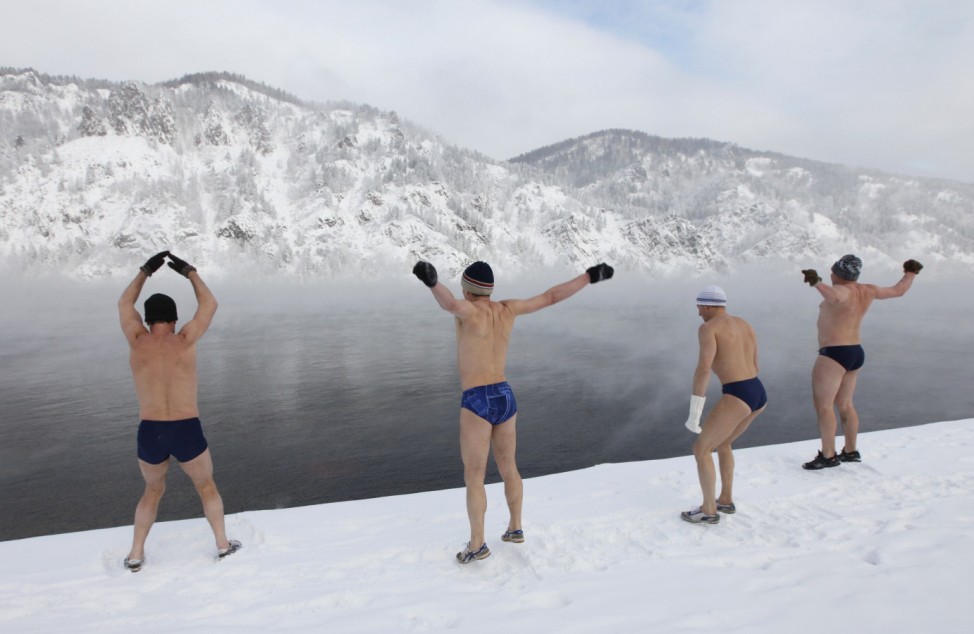 Members of a local winter swiming club warm up on the bank of the Yenisei River in the town of Divnogorsk