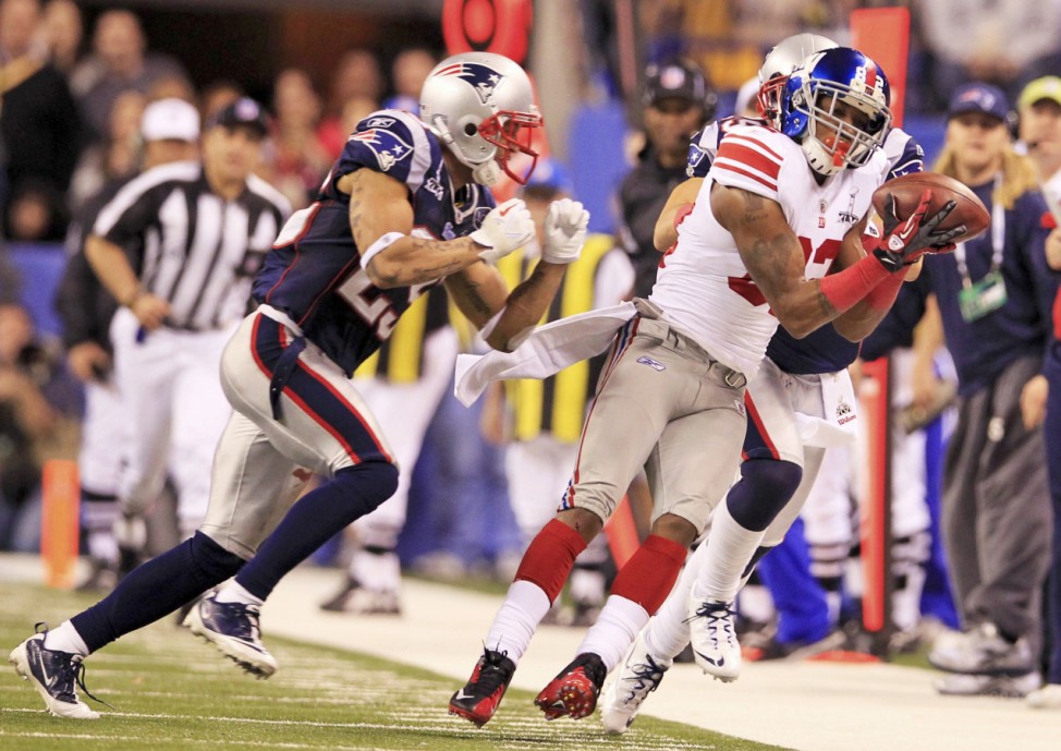 New York Giants wide receiver Mario Manningham makes a catch as New England Patriots free safety Patrick Chung (L) watches during the fourth quarter