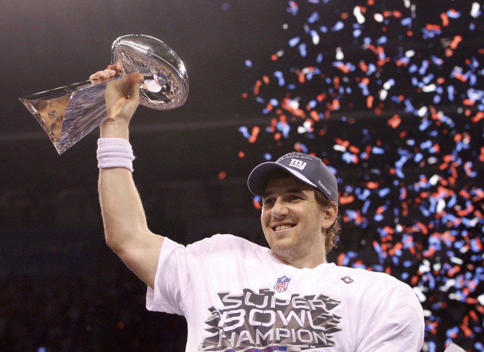New York Giants quarterback Eli Manning holds up the Vince Lombardi Trophy after defeating the New England Patriots in the NFL Super Bowl XLVI football game in Indianapolis