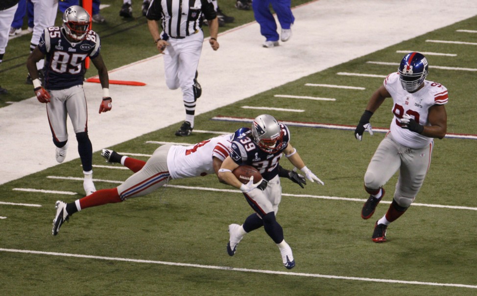 New England Patriots running back Woodhead runs with the ball as the New York Giants Grant attempts to tackle him at the NFL Super Bowl XLVI football game in Indianapolis