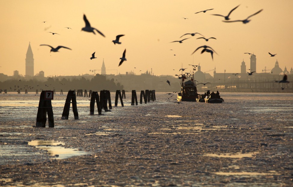 Fishing boats are seen on a frozen lagoon in Venice