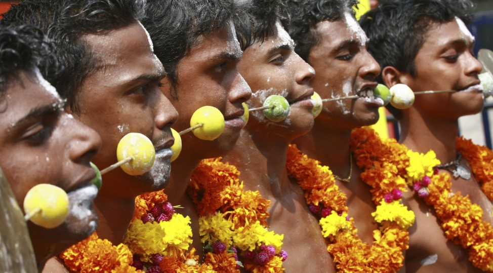 Hindu devotees with pierced tongues take part in a procession during the Thaipusam festival in the southern Indian city of Kochi