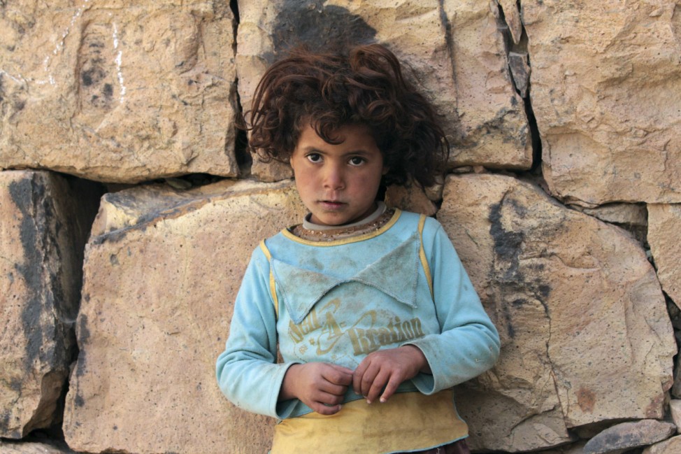 A girl stands next to a wall in Bayt Boss village, south of the Yemeni capital Sanaa