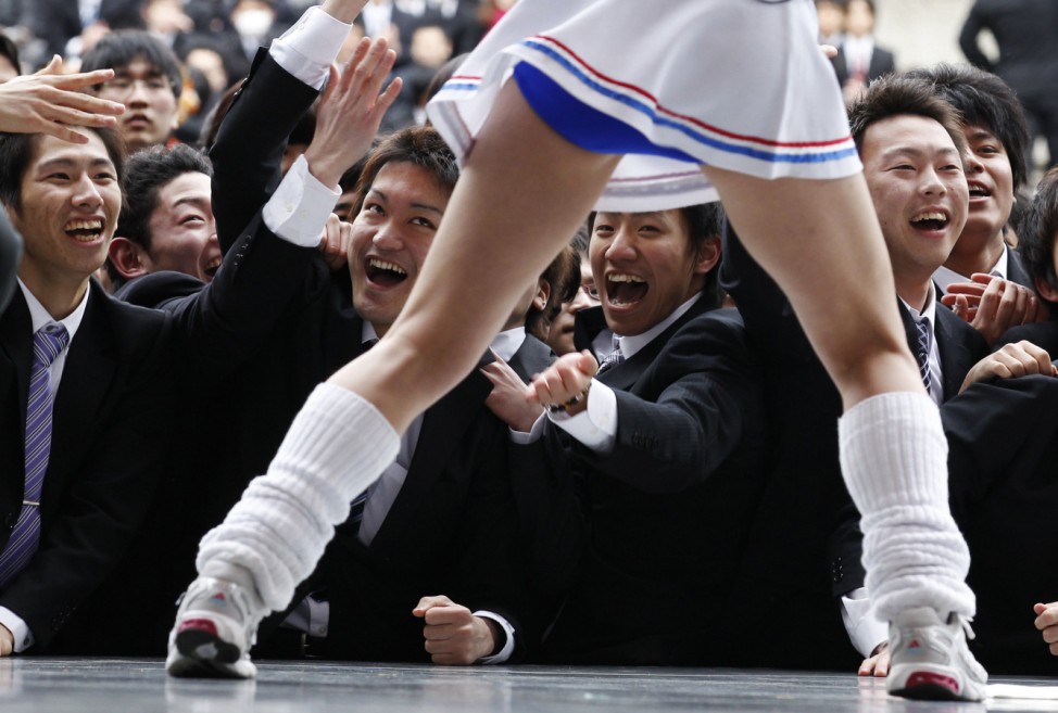 Japanese college students watch a cheerleader at a rally wishing for success in their job search in Tokyo