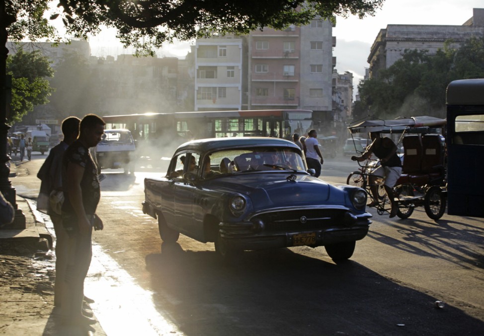 People wait to cross a street in Havana