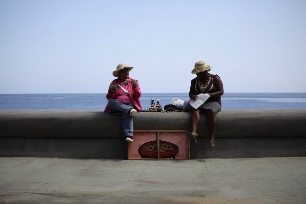 Women with a private license to sell souvenirs wait for customers on Havana's seafront boulevard 'El Malecon'