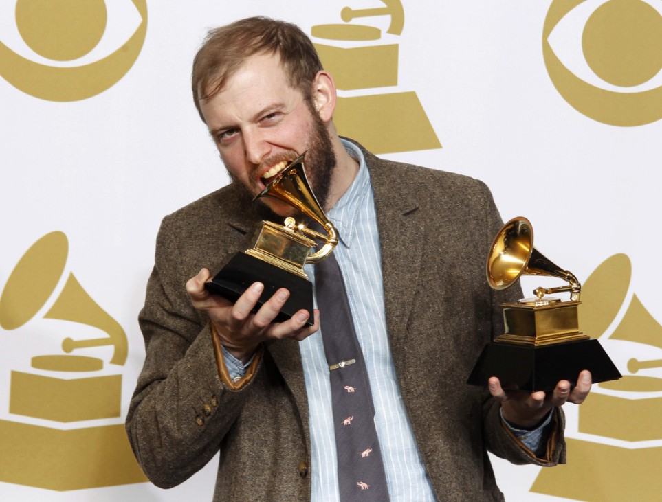 Singer Bon Iver bites one of his two Grammy Awards in Los Angeles