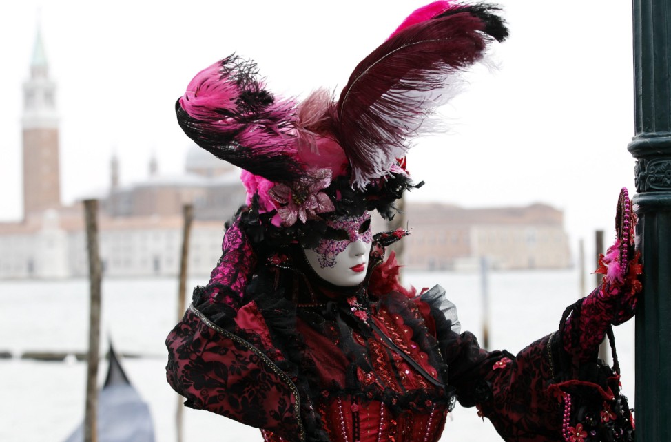 A masked reveller poses in Saint Mark's Square during the Venetian Carnival in Venice