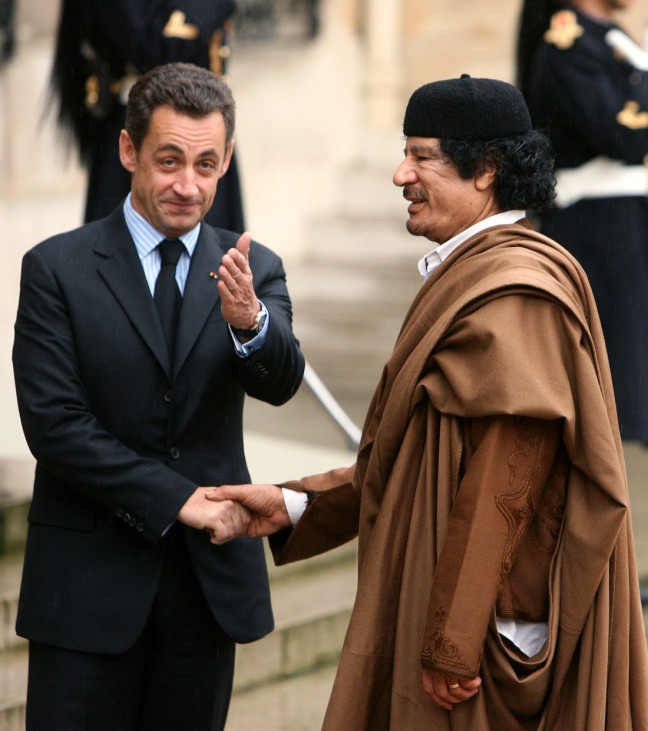 France's President Nicolas Sarkozy greets Libyan leader Muammar Gaddafi in the courtyard of the Elysee Palace in Paris
