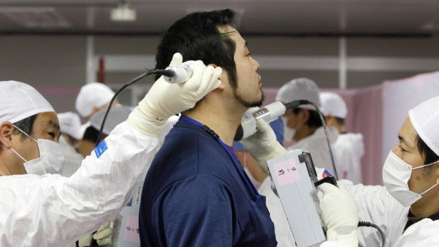 Atomkatastrophe in Fukushima: Ein Arbeiter des havarierten Atomkraftwerks Fukushima Daiichi wird auf radioaktive Strahlung gescannt (Foto vom Februar 2012).