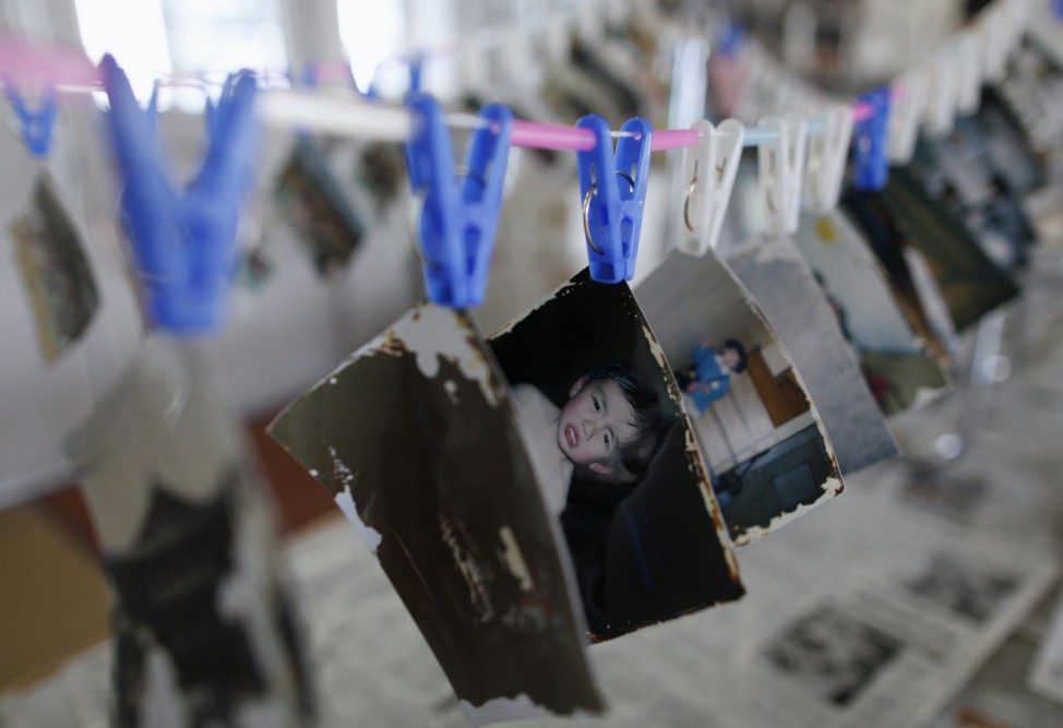 Photographs, which were washed away by the March 11, 2011 earthquake and tsunami, are hung to dry after cleaning in Ofunato