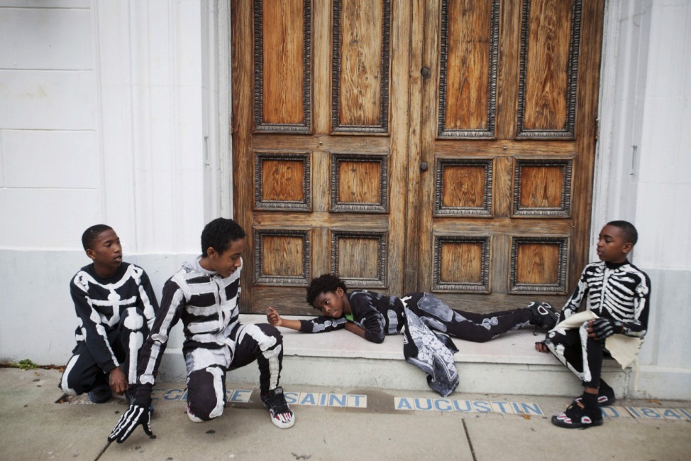 Members of North Side Skull and Bone Gang rest at church doorway on Mardi Gras day in New Orleans