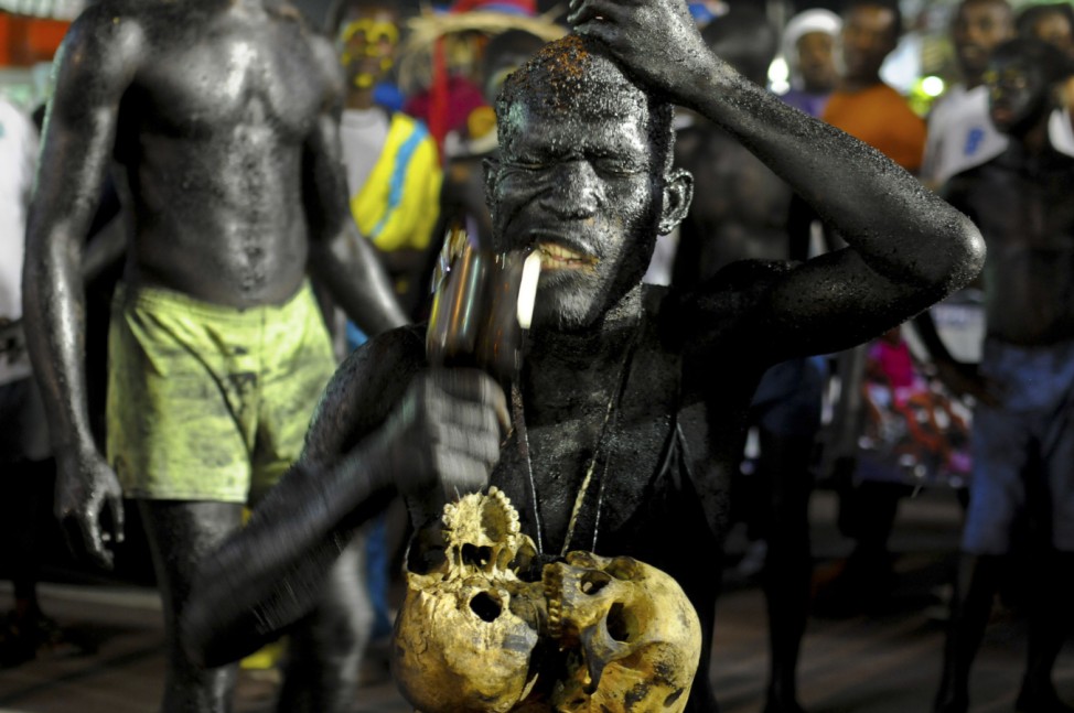 A Carnaval goer eats glass during Carnaval in Haiti's third largest city, Les Cayes