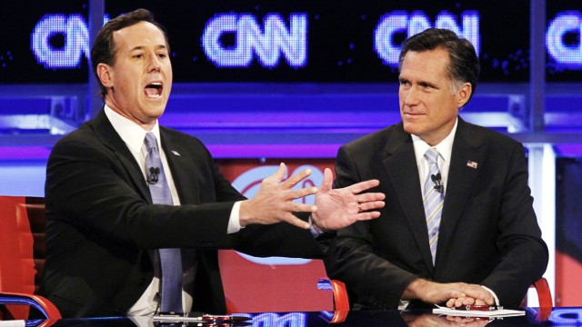 U.S. Republican presidential candidate Santorum speaks as Romney looks on during the Republican presidential candidates debate in Mesa