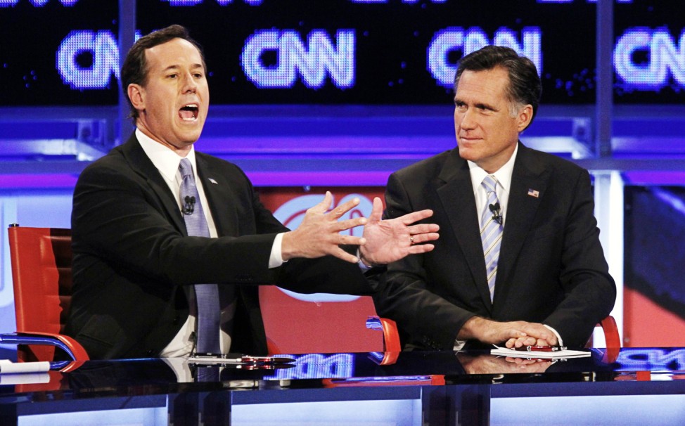 U.S. Republican presidential candidate Santorum speaks as Romney looks on during the Republican presidential candidates debate in Mesa