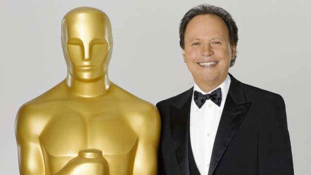 Comedian Billy Crystal, host for the 84th Academy Awards, poses in this undated publicity photograph with a large Oscar statuette