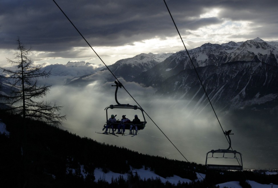 Ski racers sit on the chairlift in the early morning before the first run of the men's Alpine Skiing World Cup Giant Slalom race in Crans-Montana