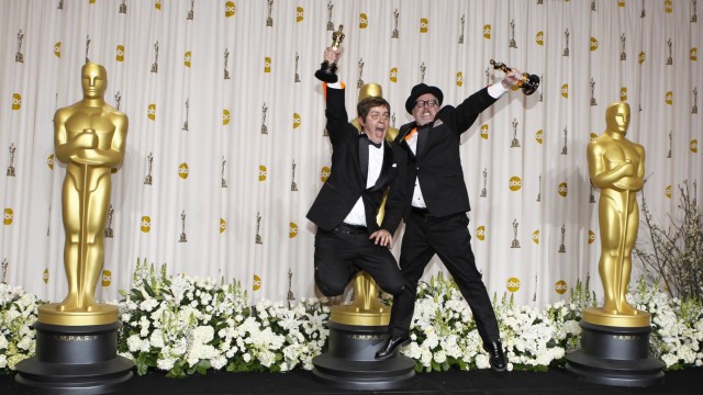 Joyce and Oldenburg, winners of best animated short film for 'The Fantastic Flying Books of Mr. Morris Lessmore', jump during 84th Academy Awards in Hollywood