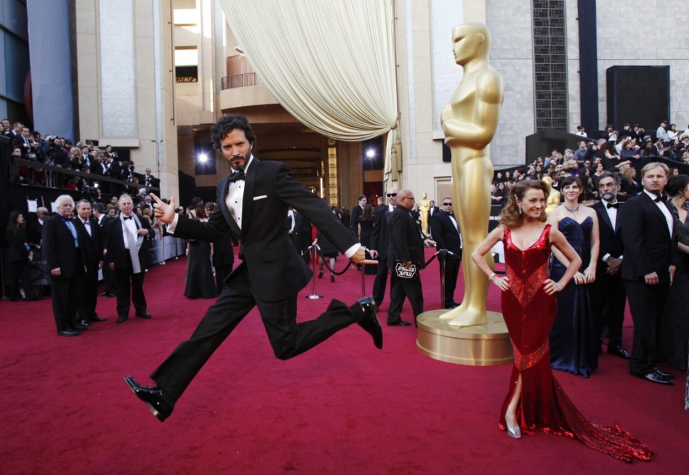 Bret McKenzie, nominated for the original song award, jumps near actress Jane Seymour posing at the 84th Academy Awards in Hollywood