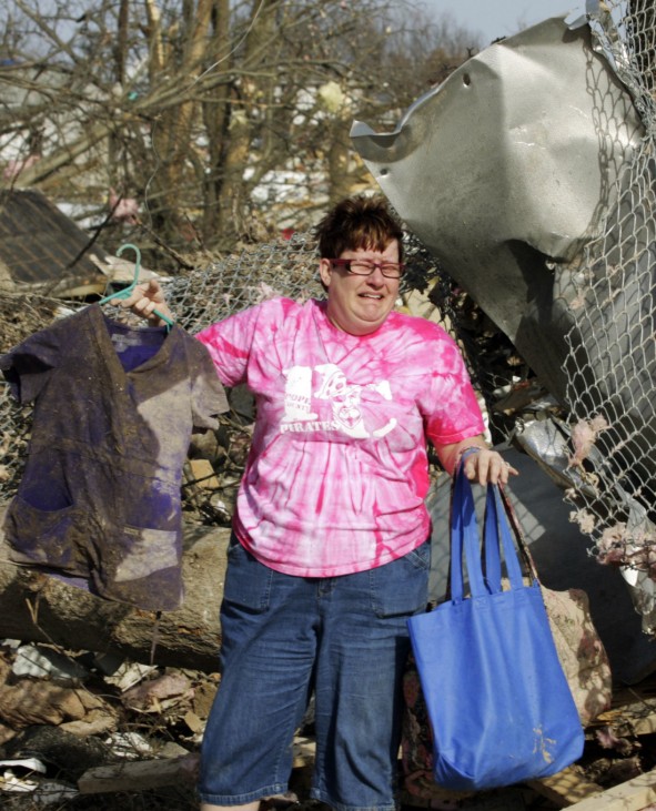 Patty Ferrell is overcome by emotion as she discovers a pair of nursing scrubs that belonged to her daughter in the debris after a tornado struck Harrisburg, Illinois